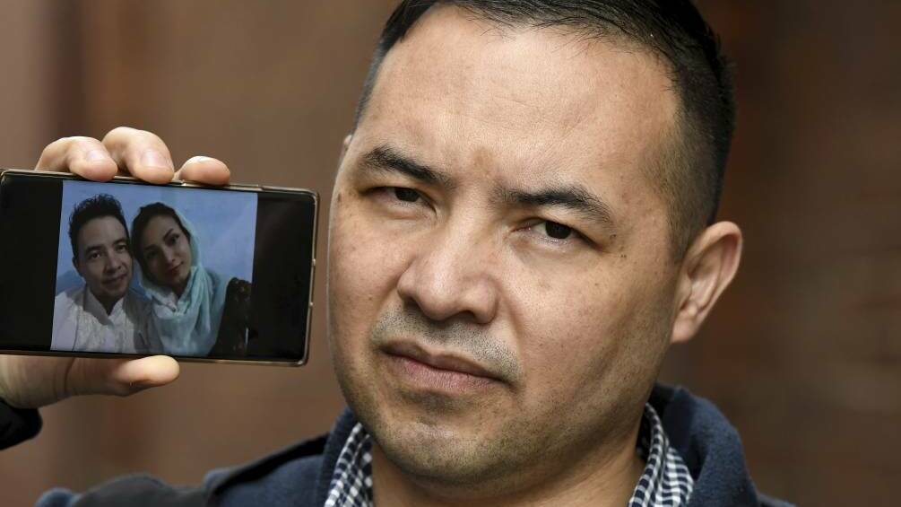 Afghani man Nadir Heidari with images of his family trapped in Kabul 