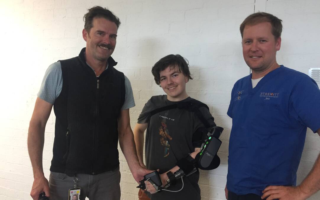 NEW ADVENTURE: Caseworker/physiotherapist Damien Barratt (left) and Jens Baufeldt, of Extremity Prosthetics and Orthotics in Nowra with Khy Antoniazzo and his new MyoPro powered arm.