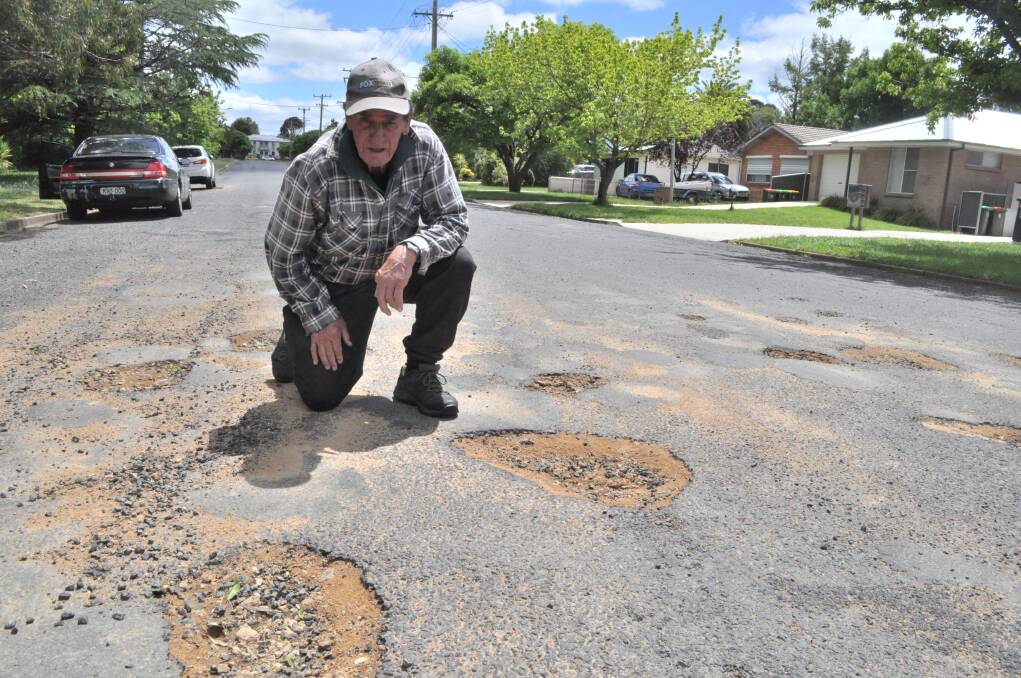 FALLING APART: Mick Wright points out some of the potholes on Sampson Street. Photo: NICK MCGRATH.