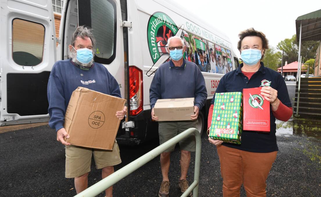 SPECIAL DELIVERY: Graham McWhirter, Neil Carles and Robyn Hicks with some of the gift boxes heading to disadvantaged children for Christmas. A working bee will be held this weekend to help pack more. Photo: Jude Keogh
