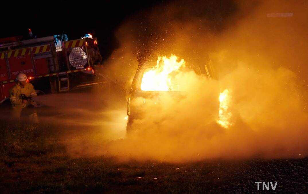 ENGULFED: Firefighters work to extinguish the fire in the 2001 Toyota Landcruiser on Wednesday night. The car had been left by the side of the road after breaking down last week. Photo: TROY PEARSON/TNV