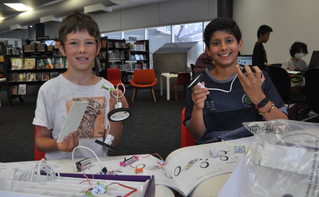 HOLIDAY HAPPY: Kaj van Simkock and Lenny Iyer at working on electronic car building at the Orange Library. The workshop was one many school holiday activities being offered by Orange City Council this year. Photo: NICK MCGRATH 