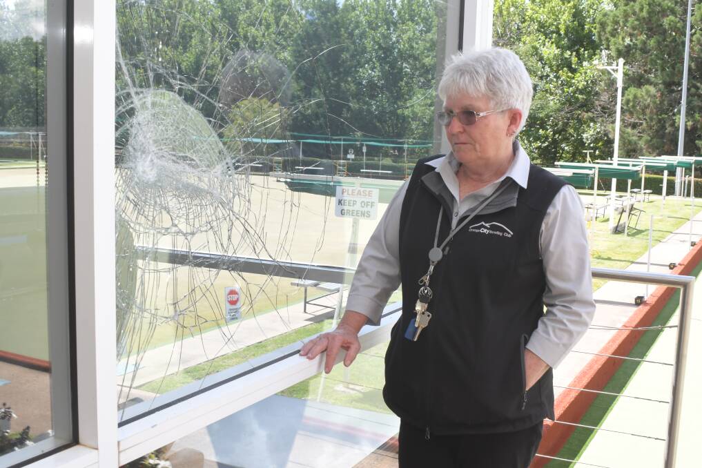 VANDALISED: Orange Bowling Club duty manager Sue Gore inspects one on the windows smashed during Tuesday morning's attack. Photo: JUDE KEOGH