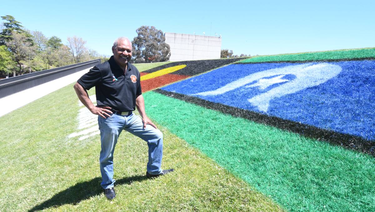 HEAL COUNTRY: Gerald Power with the flags painted at the Orange Regional Museum for NAIDOC Week.