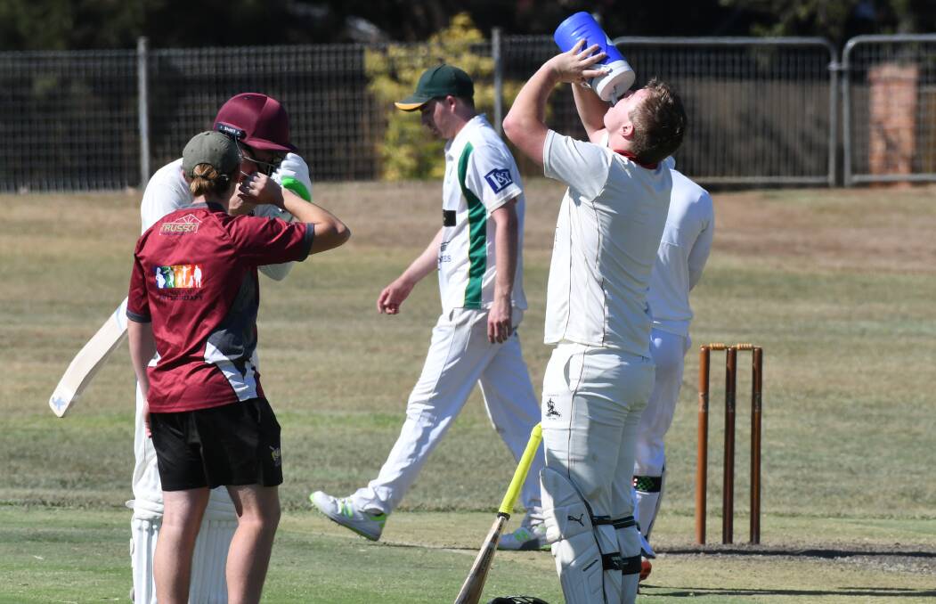 THIRSTY WORK: Kaleb Cook chugs down some water during his five-hour stay at the crease in Bathurst on Saturday. Photo: CHRIS SEABROOK. 