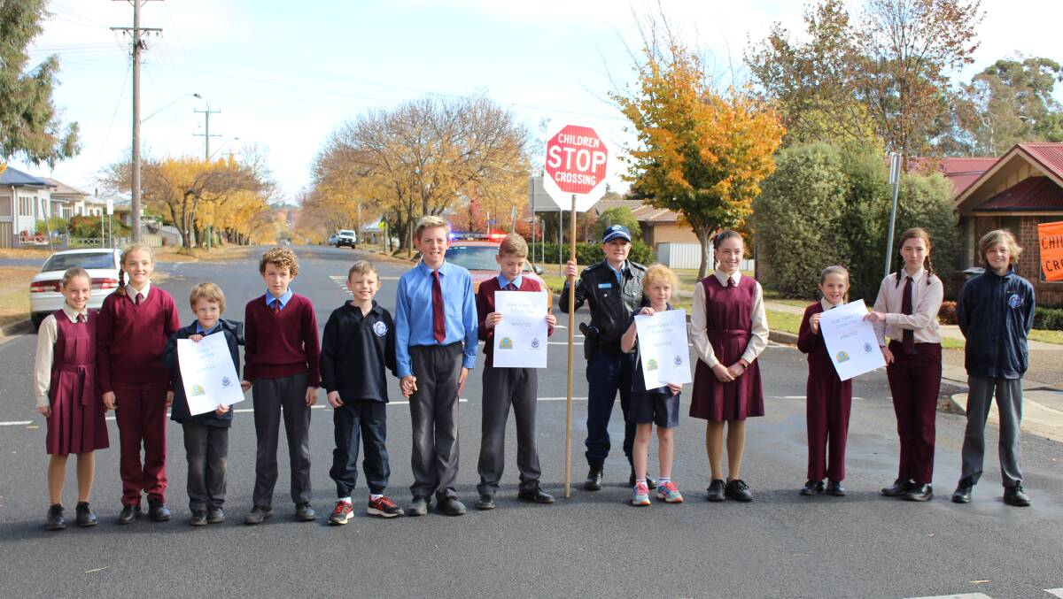 SAFETY FIRST: Students at St Mary's Catholic Primary School crossing the road with help from Central West Police District's senior constable Kirstie Delany. Photo: MAX STAINKAMPH 0518MSwalk1