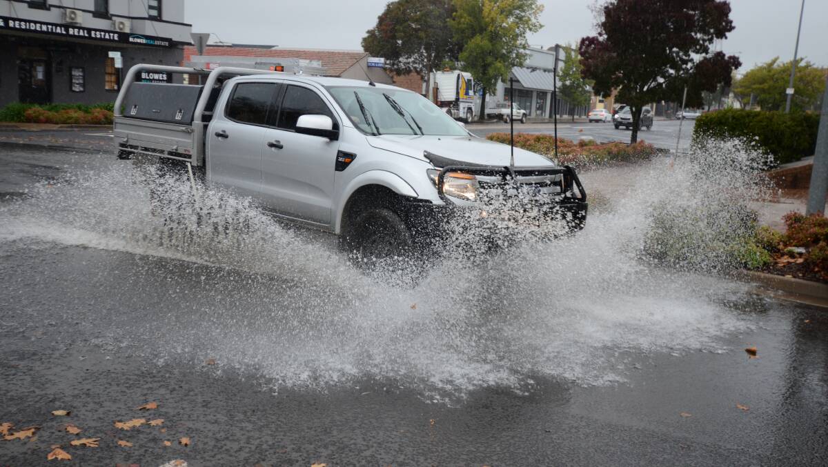 RAINS COMING: A car splashes its way through puddles during rain earlier in the week. Photo: JUDE KEOGH