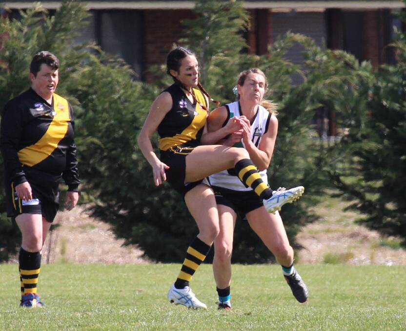 QUICK KICK: Tigers midfielder Jacqui Harris pumps the ball forward under pressure during 2019. Photo: MAX STAINKAMPH