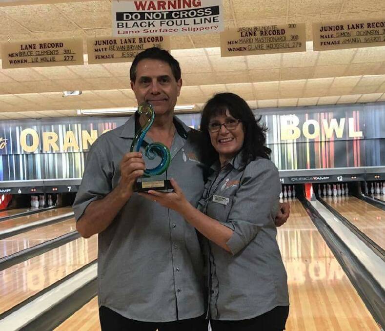 BRING IT HOME: Aldo Belmonte with his wife Marisa with the very fancy green swirl that is the Tenpin NSW Doc Kee award at Orange Tenpin Bowls last week. Photo: SUPPLIED. 