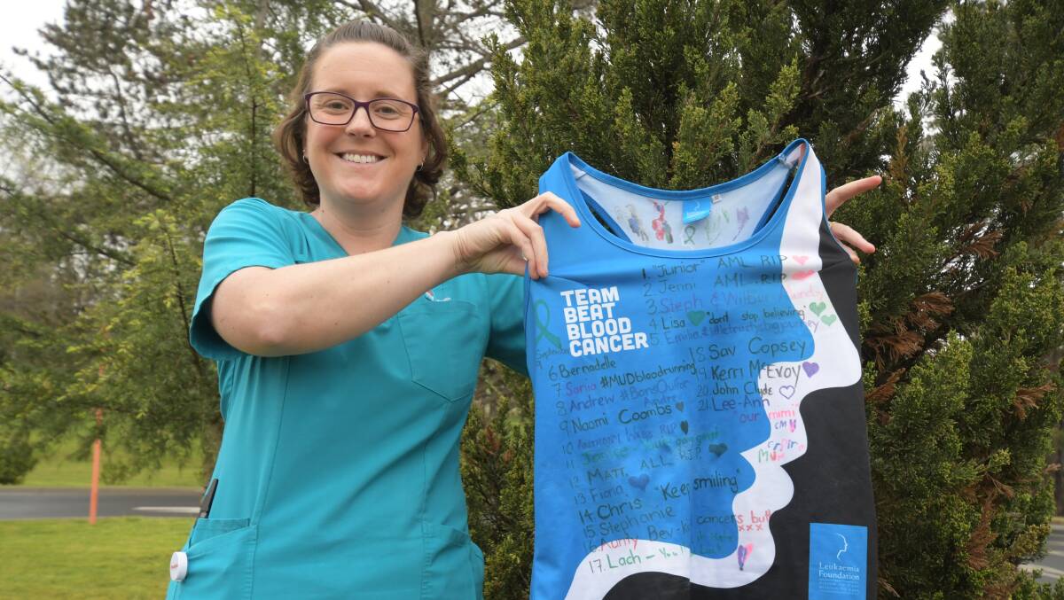 NOT RUNNING ALONE: Kate Wright with her running singlet featuring names of her patients at Orange hospital. Photo: JUDE KEOGH
