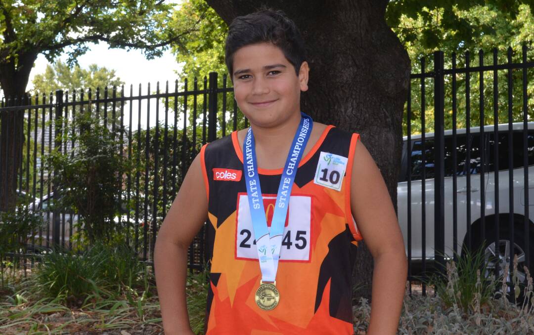 PROUD AS PUNCH: Noah Voatangi in his Orange Little Athletics singlet and with his prized gold medal. Photo: MAX STAINKAMPH