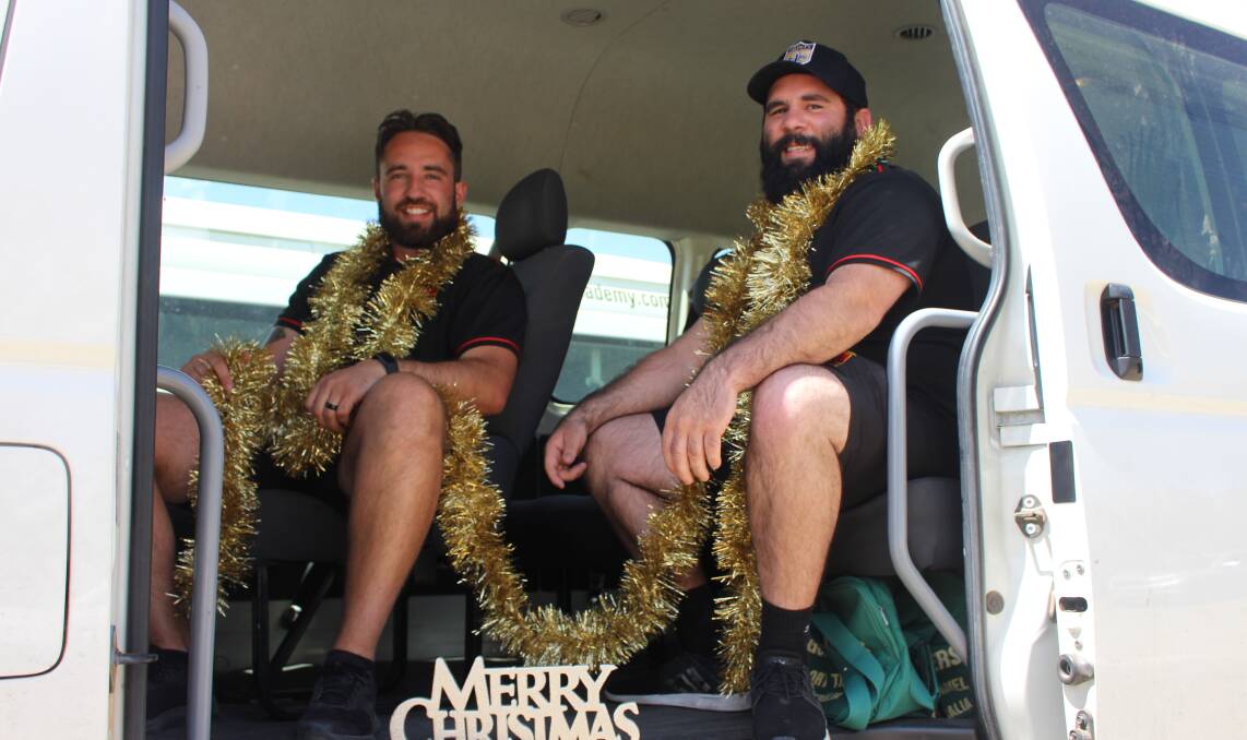 FESTIVE CHEER: Matty Georgiou and Tom Goolagong in the back of the Christmas van which will be doing rounds on Christmas Eve. Photo: MAX STAINKAMPH