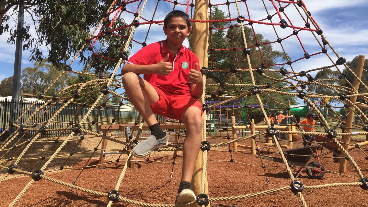 KEEN AS A BEAN: Glenroi Heights Public School student Chase Dixon trying out the new climbing frame. Photo: MAX STAINKAMPH