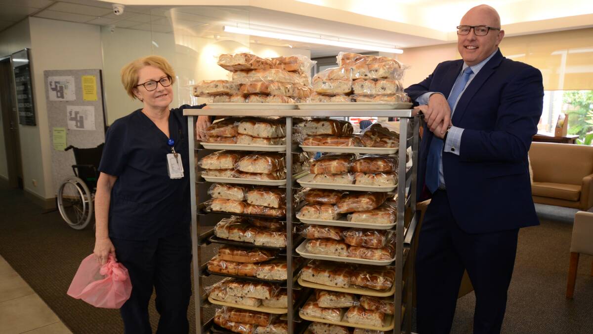 HOPPING IN: Clinical nurse specialist Carolyn Gillespie and Dudley Private Hospital CEO Paul McKenna with a delivery of hot cross buns on Wednesday. Photo: JUDE KEOGH