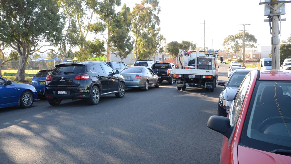 BYPASSING THE LINE: A truck is forced onto the wrong side of the road on Lords Place due to a row of cars waiting for school pickup. Photo: JUDE KEOGH