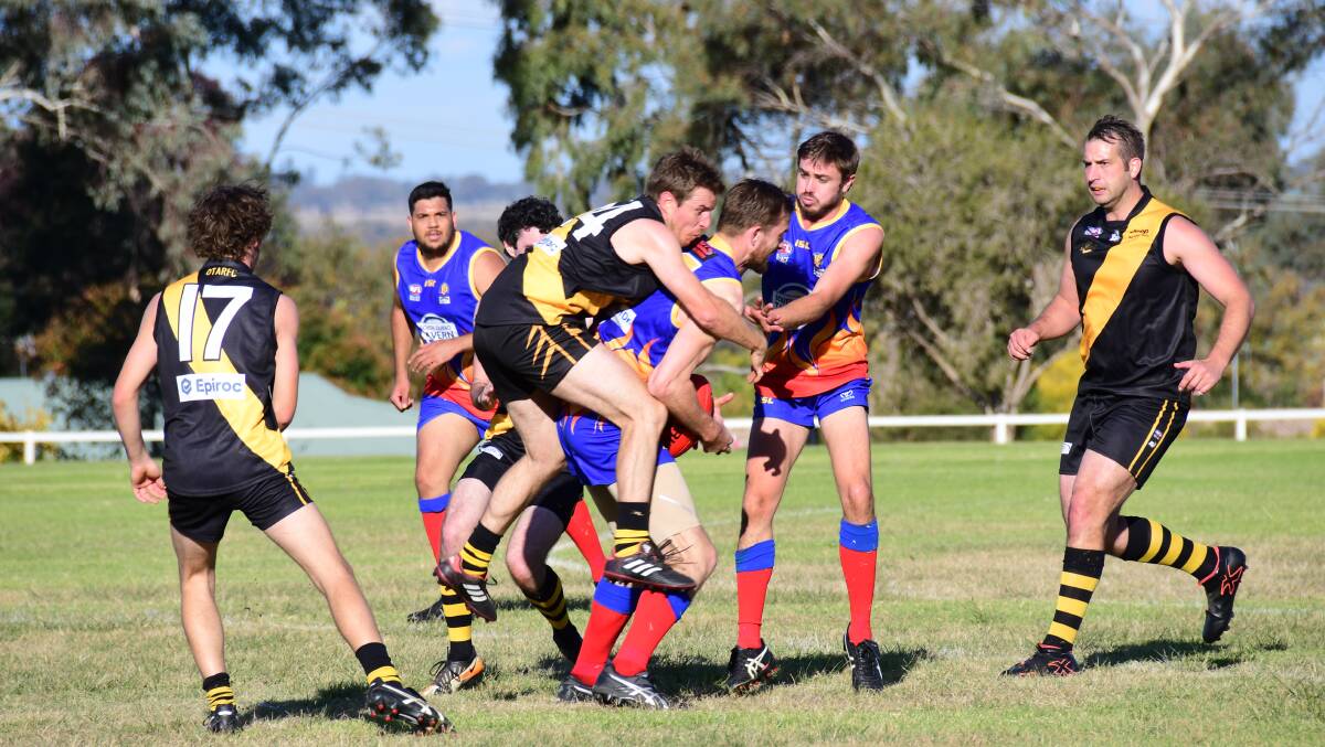 BEAR HUG: Tigers midfield stalwart Mitch McKenna jumps into a tackle during Saturday's win in Dubbo. Photo: AMY McINTYRE
