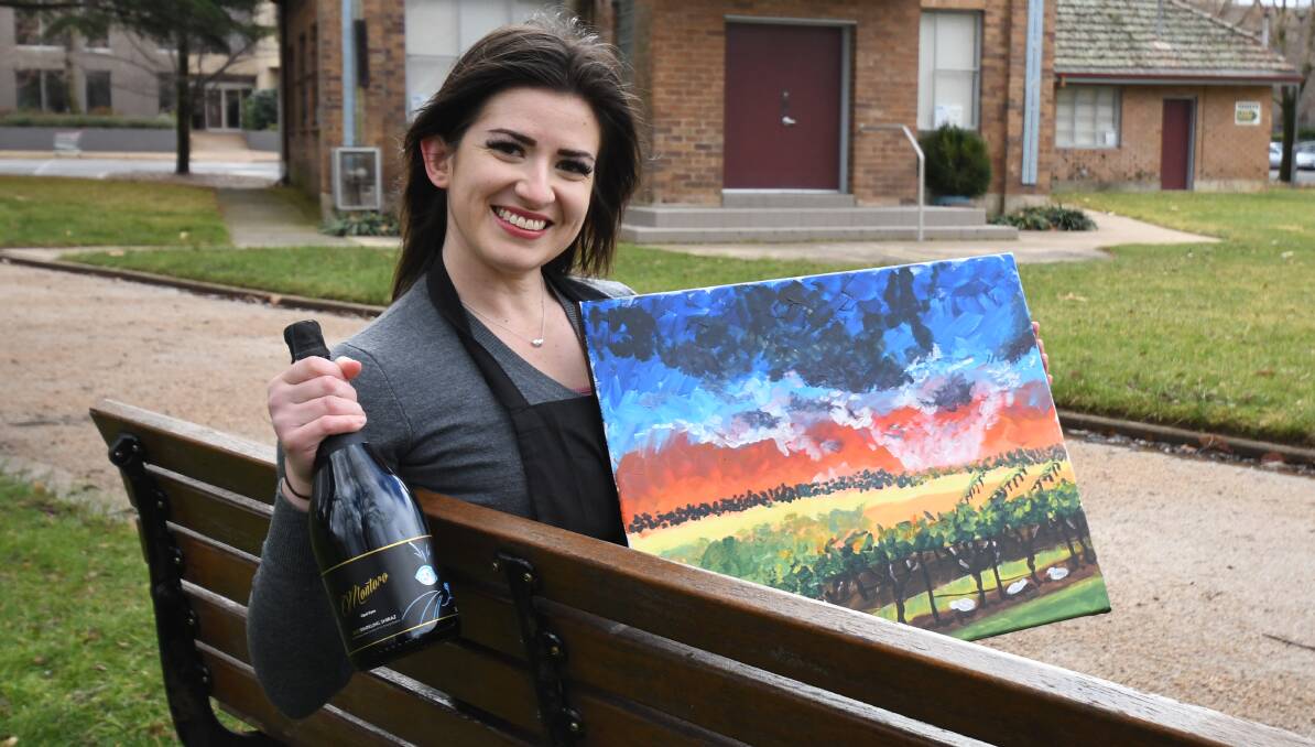 BUBBLES AND BRUSHES: Lena Hughes with a painting put together with some help from a glass of bubbly. Photo: CARLA FREEDMAN 0715cfbubbles3