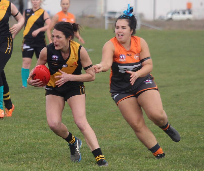 SEASON OVER: Tigers midfielder Jacqui Ryan runs away from a Giants defender in their second-last game last weekend. Photo: MAX STAINKAMPH