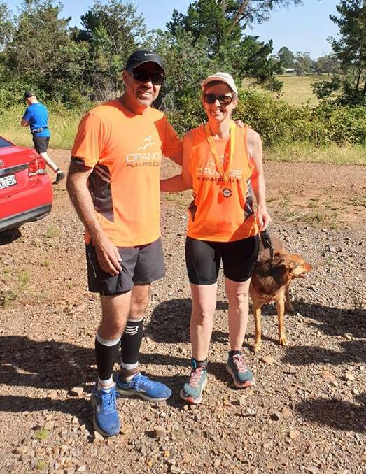 MASSIVE EFFORT: Kim Jarvis (right) being presented her 1500 run medal by Club President Anthony Daintith last Sunday at Berrilee Forest. Photo: SUPPLIED. 