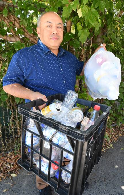 HOLDING ON: Rodney Soo with some of the bottles and cans he is waiting to recycling at the Orange Return and Earn. Photo: JUDE KEOGH 0227jkreturn1
