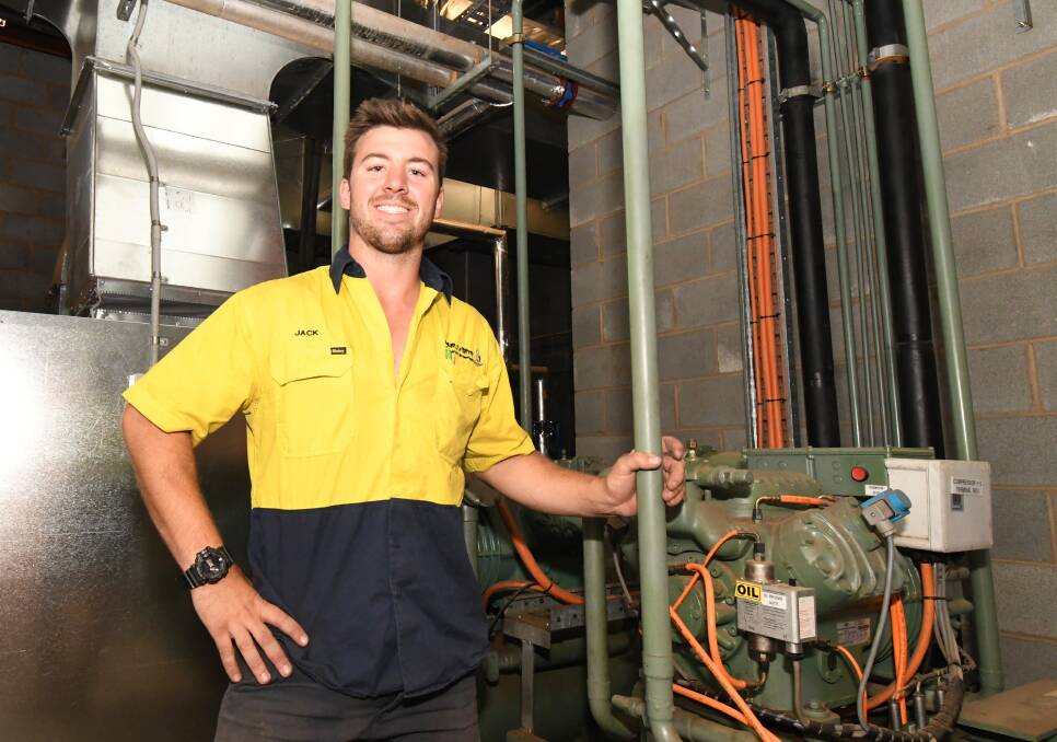 KEEPING COOL: Jack Marchinton with one of the bigger air-conditioning units he has to face in his job. Photo: JUDE KEOGH