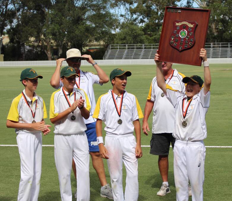 CHAMPIONS: South Coast captain Joel Whalan hoists the shield up high after his side took out the 2018 under-13 tournament. Photo: MAX STAINKAMPH