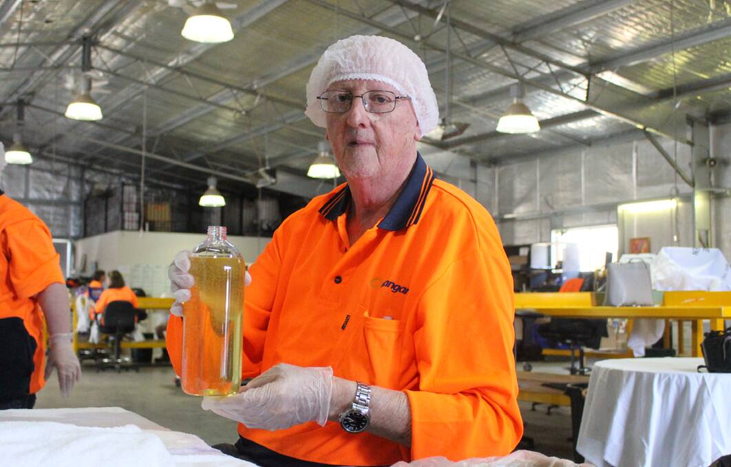 FILLED RIGHT UP: Allan Roberts with the filled bottle of canola oil at Wangarang. Photo: MAX STAINKAMPH