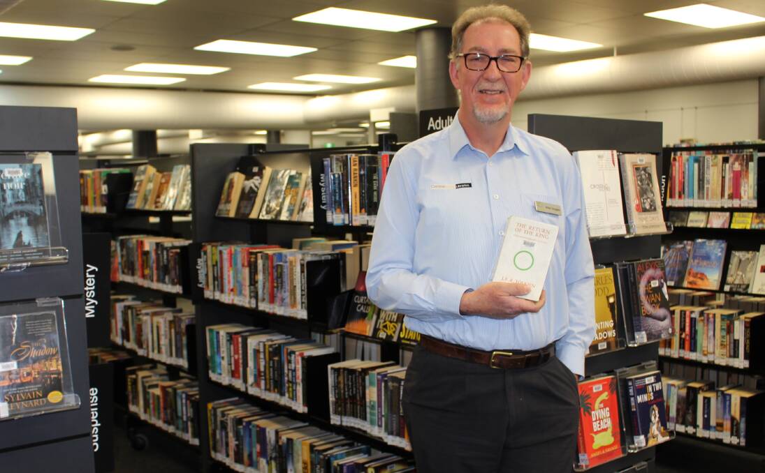 SURROUNDED BY BOOKS: Peter Douglass holding one of the library's copies of the Return of the King. Photo: MAX STAINKAMPH 0810MSdouglass1