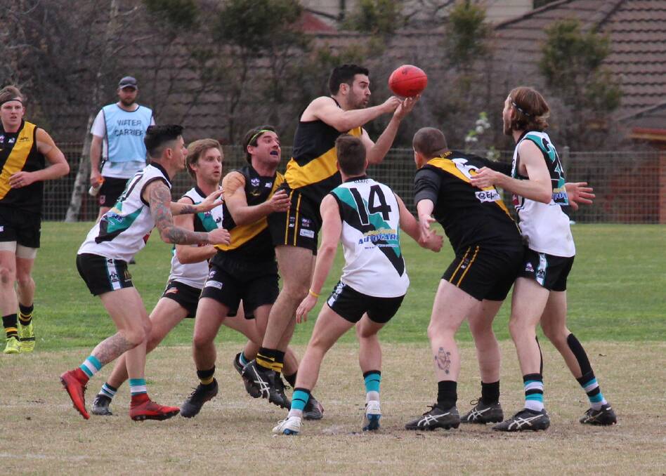 STANDING UP: Lucas Kelly dishes the ball out of a pack in the grand final. Photo: MAX STAINKAMPH. 