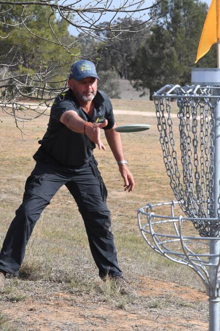 LET IT RIP: Kevin Costa putts into the hole during the disc golf NSW Open. Photo: CARLA FREEDMAN. 
