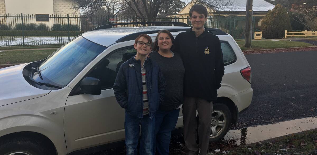 HAPPY TIMES: Jacqui Fowler with sons Justin and James standing in front of their newly fixed car after it broke down on Thursday. Photo: SUPPLIED.