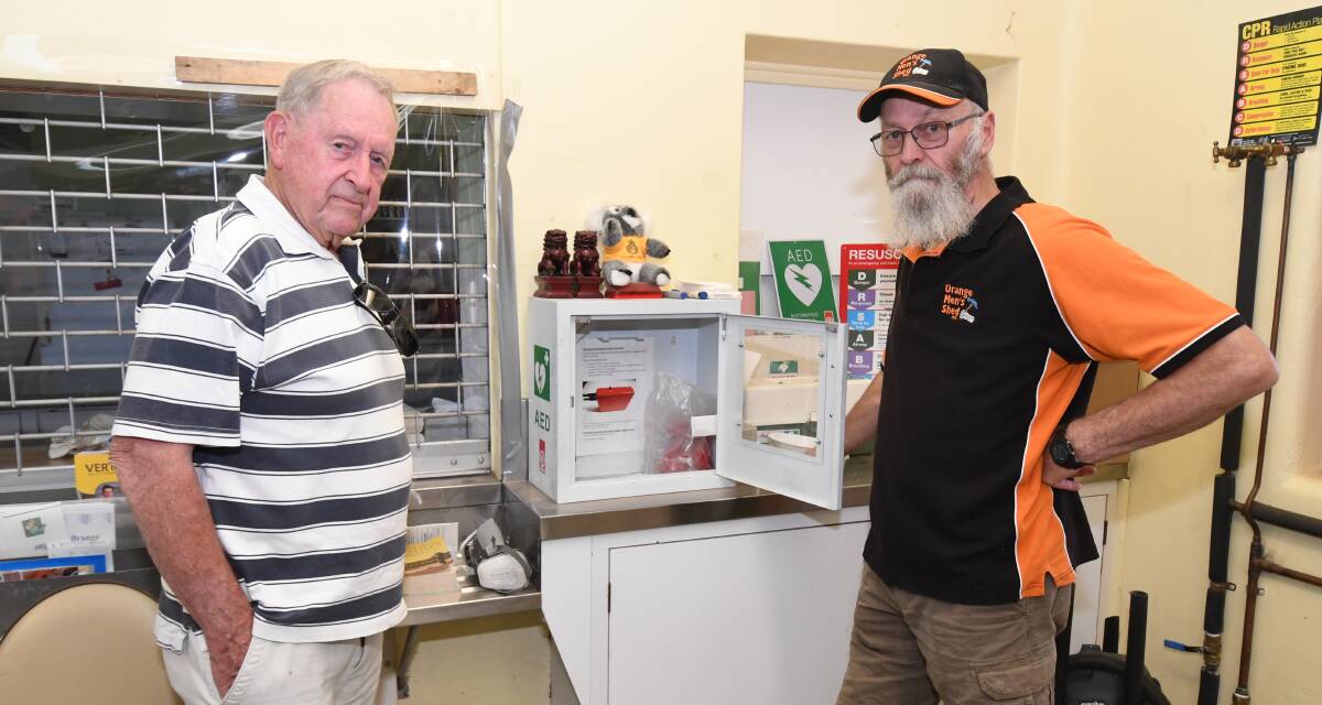 DISGUSTING: Jim Doak and Terry Betts where the defibrillator was kept before it was stolen from the Orange Men's Shed on Wednesday night. Photo: JUDE KEOGH.