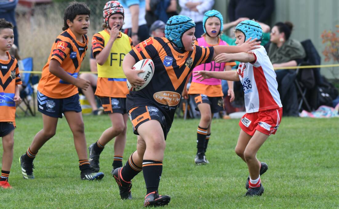 PUNISHMENT: Harry Laverty with the stiff-arm during one of the gala day games. Photo: CARLA FREEDMAN.