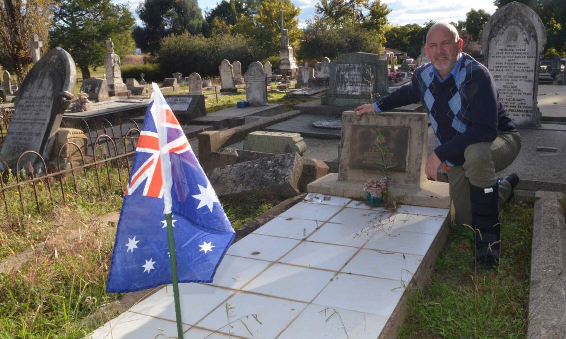 THOUGHTFUL: Jason Hamling next to one of the graves where an Australian flag has been erected in time for Anzac Day. Photo: RILEY KRAUSE. 