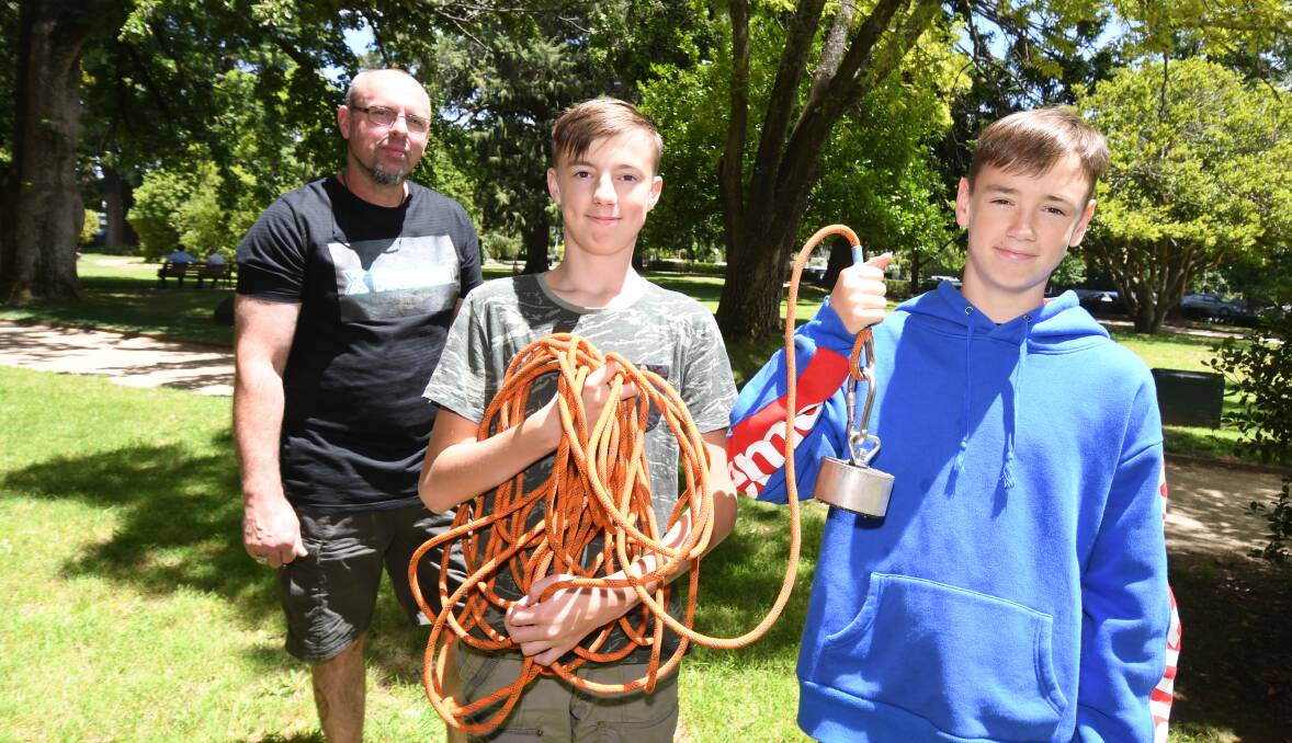 EXPLOSIVE: Phillip Henderson, Ethan Walraevens and Sylus Henderson and the magnet used to find the grenade. Photo; JUDE KEOGH