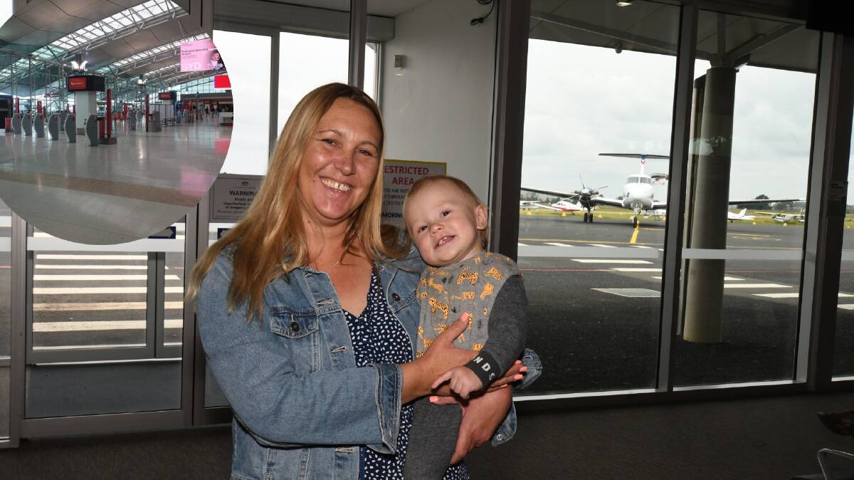 WELCOME HOME: Cindy Hotham and Kayden Ranse at Orange Regional Airport while at the same time Sydney Airport (inset) was empty. Photo; CARLA FREEDMAN.