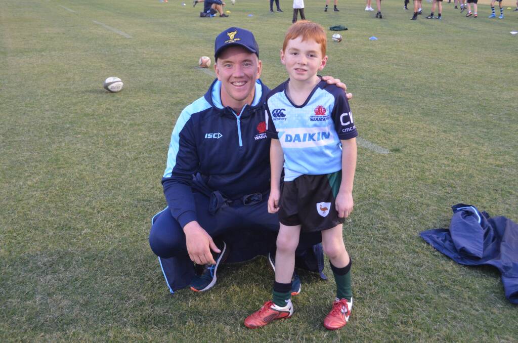 SPECIAL DAY: Waratahs flanker Hugh Sinclair with Toby Miller at Wade Park on Monday night for a meet and greet for junior fans. Photo: RILEY KRAUSE.
