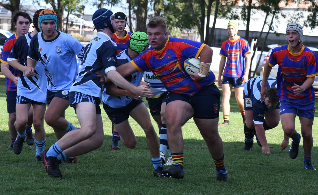 GRAND FINAL BOUND: James Sheahan's Alex Watts with the stiff-arm in their 24-10 win over Forbes Red Ben. Photo: JUDE KEOGH.