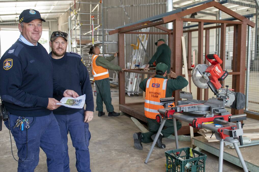 Wellington Correctional Centre inmates work on a cubby house under the supervision of Dean Matthews (L), who runs Wellingtons Modular Housing Unit. Picture by Belinda Soole