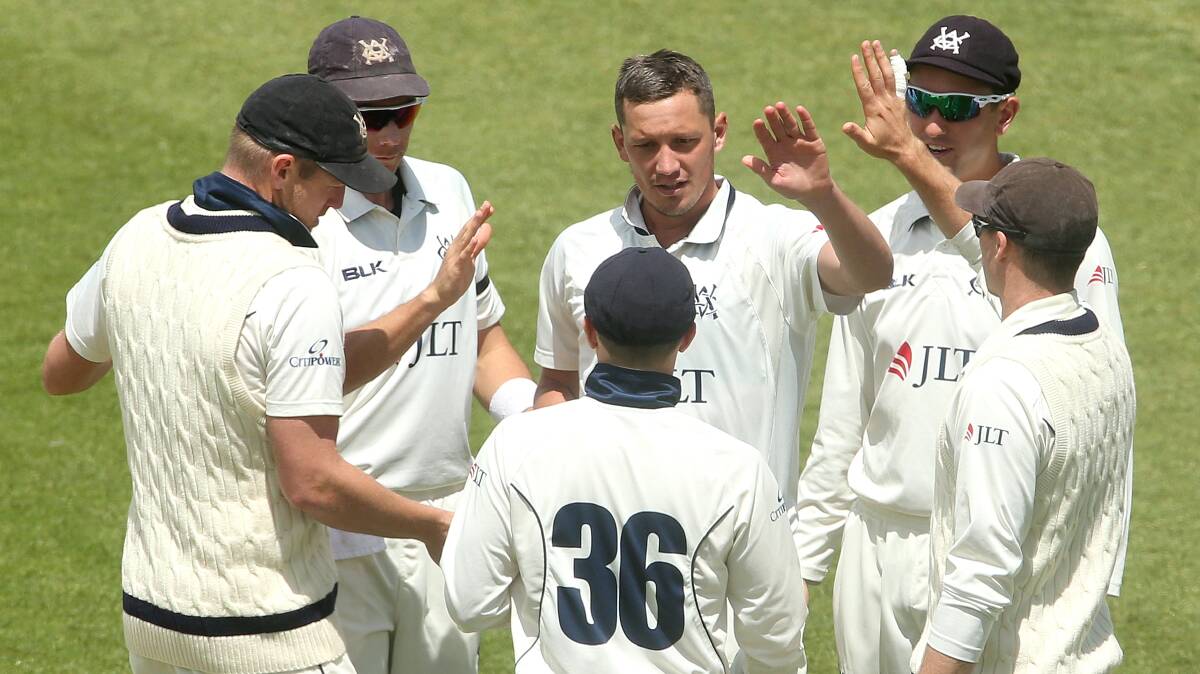 ANOTHER ONE: Chris Tremain (centre) is congratulated by Victoria teammates after one of his five wickets on Saturday. Photo: AAP/HAMISH BLAIR