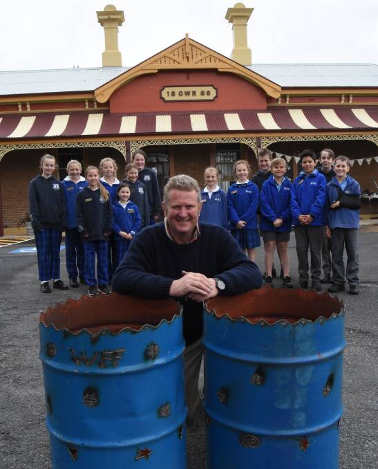 FIRED UP: Millthorpe Public School students with fire drum maker Rod de Vries ahead of the Winter Fire Festival night markets which kick-off on Friday. Photo: MARK LOGAN