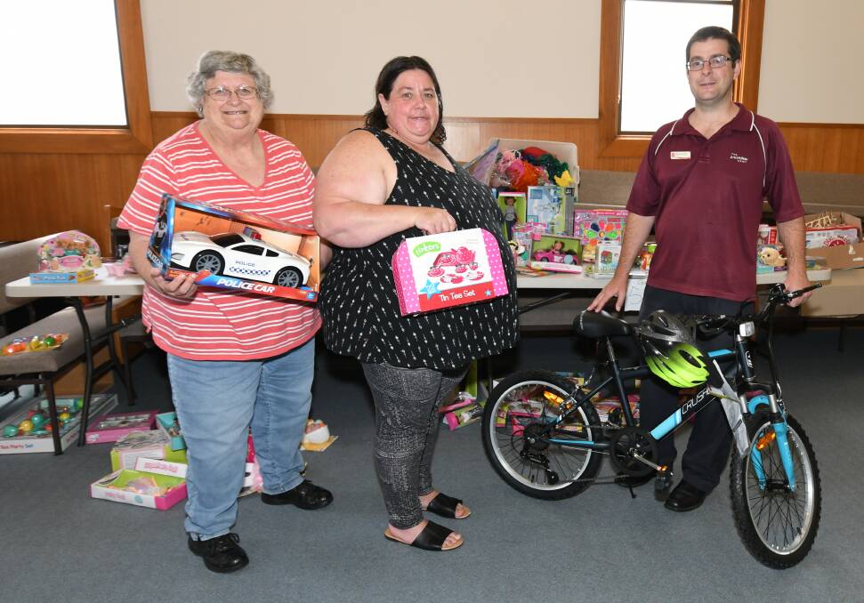 FESTIVE FUN: Lynne Luxford, Sandra-May Taylor and David Grounds sorted donated gifts to be delivered around the region for Christmas. Photo: CARLA FREEDMAN 1220cfsalvo3