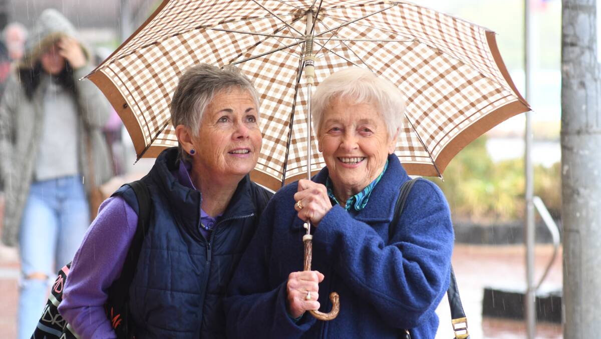 GOOD BROLLY WEATHER: Robin Thompson and Gwenda Garde were well prepared for the wintery start to summer Orange enjoyed. Photo: JUDE KEOGH