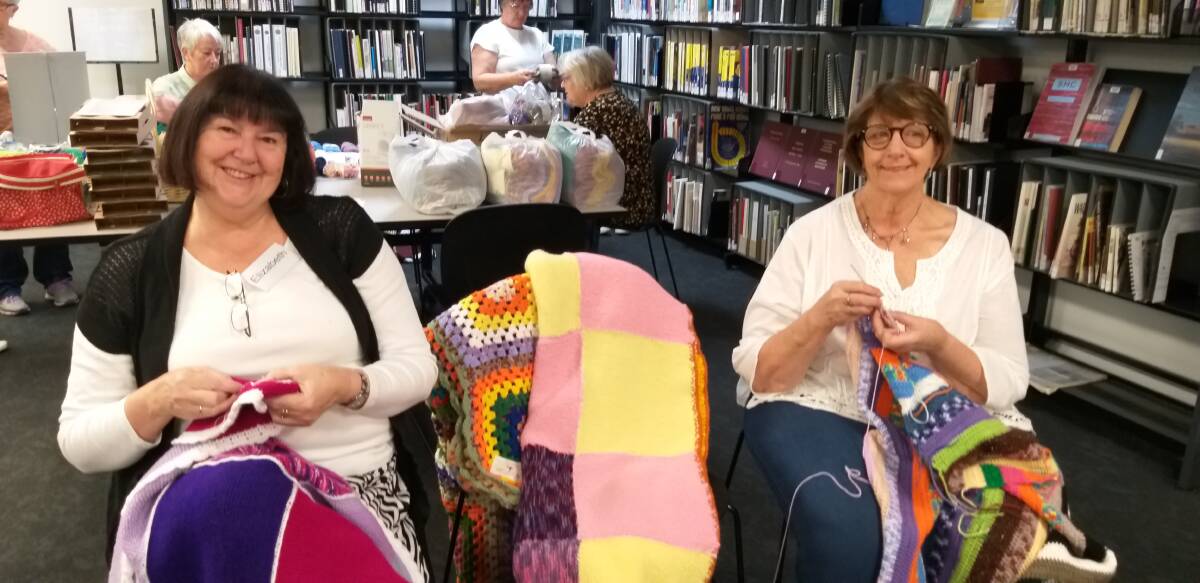 LOVE WRAP: Orange Purlers Elizabeth Buesnel and Helen Woods prepare for the Wrap With Love Knit-In at the Orange City Library. Photo: supplied.