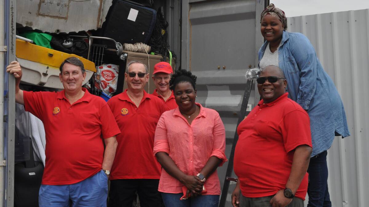 PACKED UP: Steve Jackson, David Ridges, Ray Williamson, Joyce, Mark and Nelta Jachi with the third container of goods. Photo: ALEX CROWE
