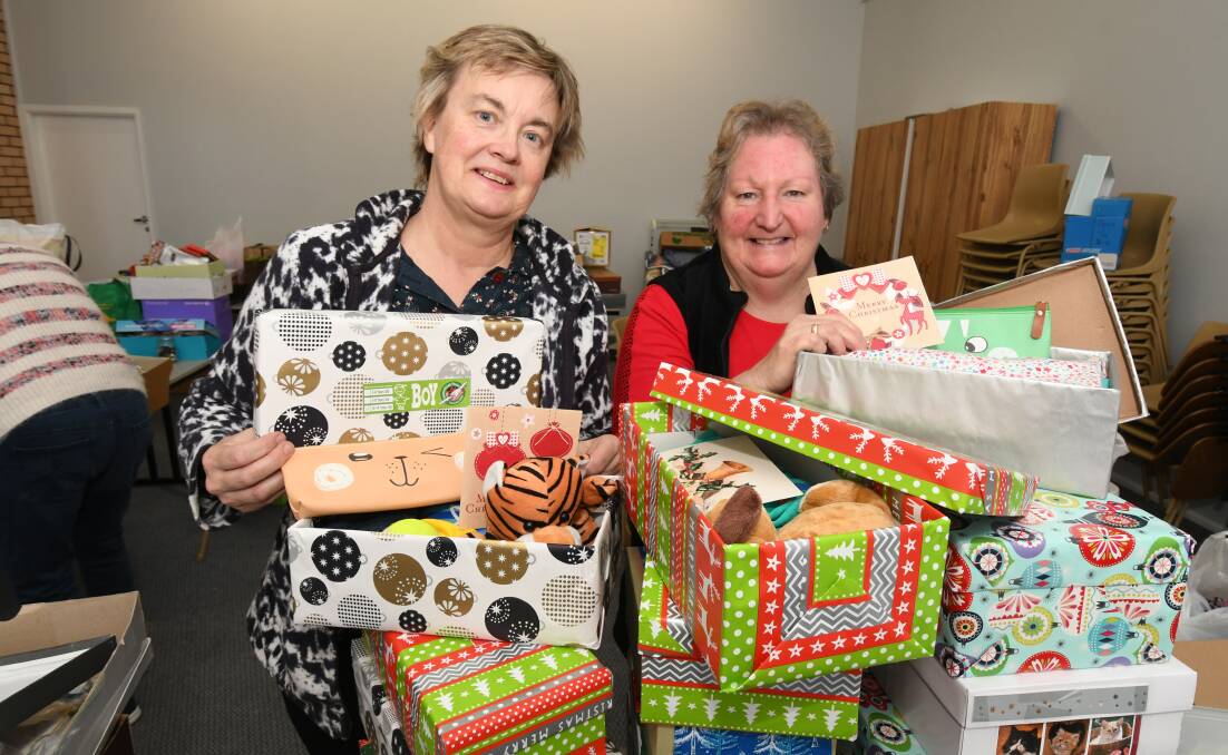X-MAS WRAP: Robyn Hicks and Jenny Abbott are two dedicated volunteers busy packing boxes for children in developing countries. Photo: JUDE KEOGH 0817jksamaritan1