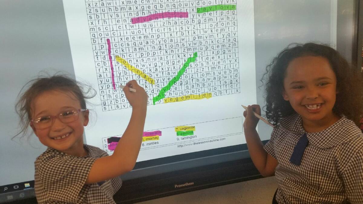TECH UPGRADE: Anna Clunas and Kayda Maki took part in a word find on the screen purchased with the winnings. Photo: supplied.