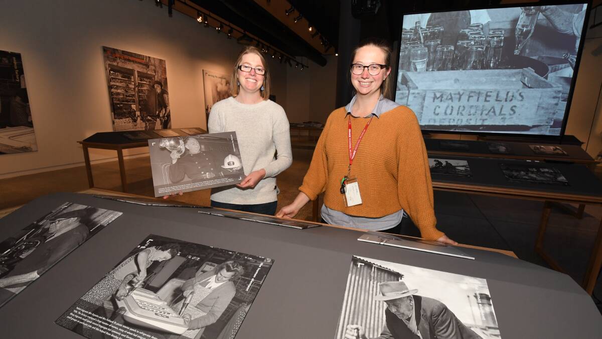 NEGATIVES EXPOSED: Orange Regional Museum's Allison Campbell and Sally MacLennan have been busy this week setting up All in A Day's Work. Photo: JUDE KEOGH