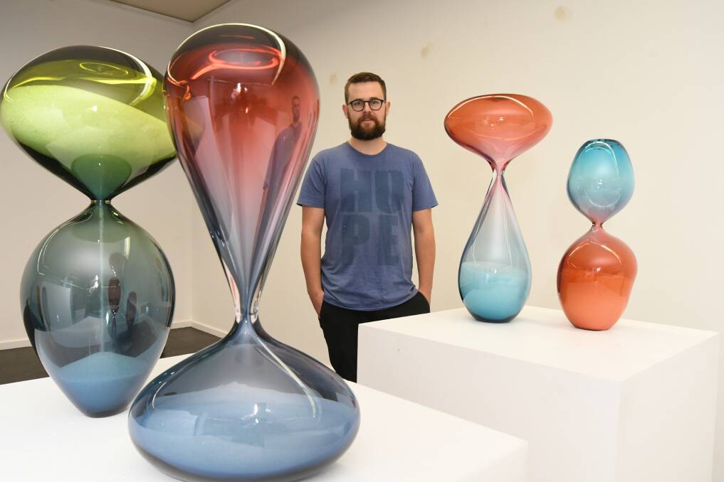 GLASS ART: Thomas Pearson returns to Orange to exhibit the hourglasses in colours inspired by the landscape. Photo: JUDE KEOGH 0619jkart1