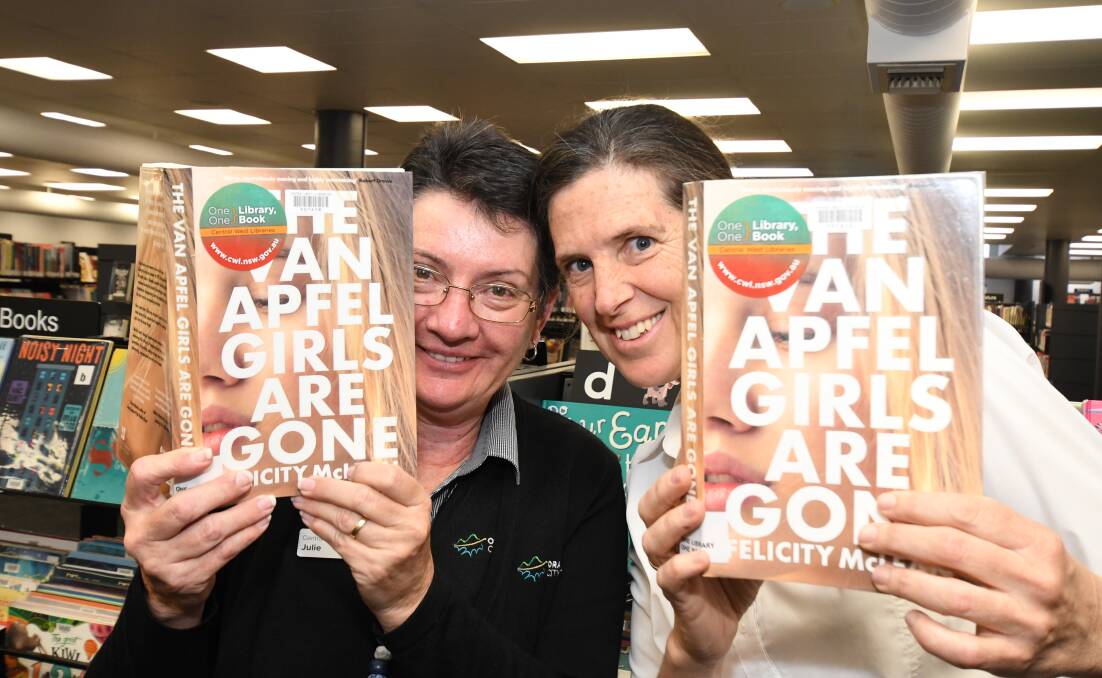 BOOK CLUB: Orange library staff Julie Sykes and Fiona Hawke with a copy of The Van Apfel Girls Are Gone by Felicity McLean which is now doing the rounds in homes right around the Central West. Photo: JUDE KEOGH